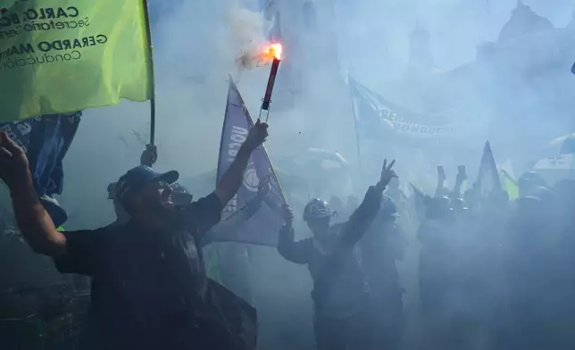 Laborers hold flares during a May Day demonstration in Buenos Aires, Argentina, Thursday, April 30, 2026. (AP Photo/Rodrigo Abd)