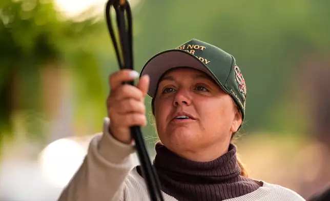 Trainer Cherie DeVaux stands watches from a barn after a workout at Churchill Downs Monday, April 27, 2026, in Louisville, Ky. (AP Photo/Charlie Riedel)