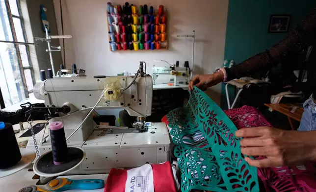 Cande Martinez prepares soccer jerseys, inspired by papel picado and traditional folk art, from the brand Mexclart, in Cuautitlán Izcalli, Mexico, Monday, May 25, 2026. (AP Photo/Marco Ugarte)