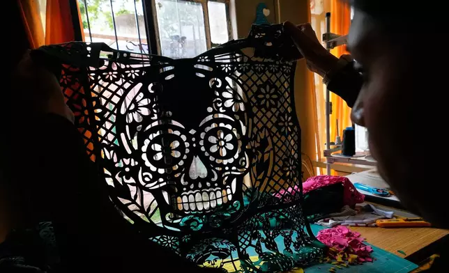 Cande Martinez prepares soccer jerseys, inspired by papel picado and traditional folk art, from the brand Mexclart, in Cuautitlán Izcalli, Mexico, Monday, May 25, 2026. (AP Photo/Marco Ugarte)