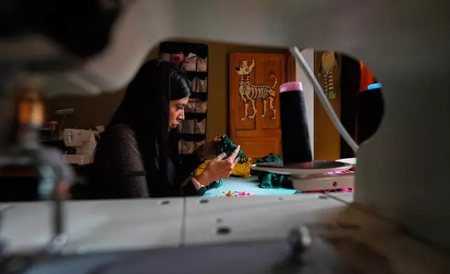 Cande Martinez prepares soccer jerseys, inspired by papel picado and traditional folk art, from the brand Mexclart, in Cuautitlán Izcalli, Mexico, Monday, May 25, 2026. (AP Photo/Marco Ugarte)