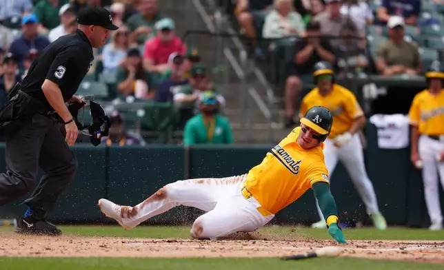 Athletics' Brent Rooker slides safely into home in the fourth inning of a baseball game against the Cleveland Guardians, Saturday, May 2, 2026, in West Sacramento, Calif. (AP Photo/Alan Greth)