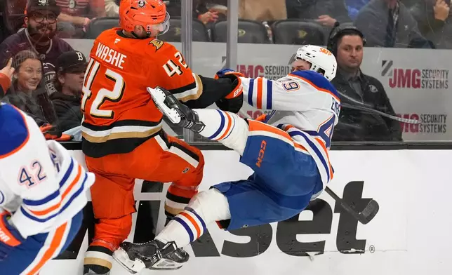 Anaheim Ducks center Tim Washe, left, puts a hit on Edmonton Oilers defenseman Ty Emberson during the second period of Game 6 in the first round of the NHL hockey Stanley Cup playoffs series Thursday, April 30, 2026, in Anaheim, Calif. (AP Photo/Mark J. Terrill)
