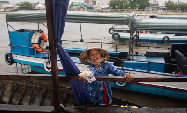 A vendor offers jackfruit slices to tourists visiting a floating market in Can Tho, Vietnam on June 22, 2024. (AP Photo/Anton L. Delgado)
