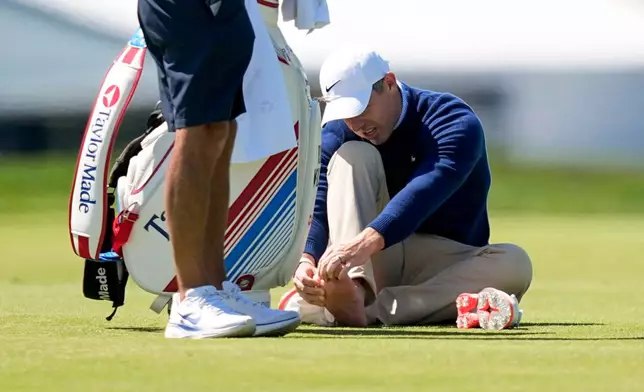 Rory McIlroy, of Northern Ireland, attends t this foot on the third fairway during a PGA Championship golf tournament practice round at Aronimink Golf Club, Tuesday, May 12, 2026, in Newtown Square, PA. (AP Photo/Matt Slocum)