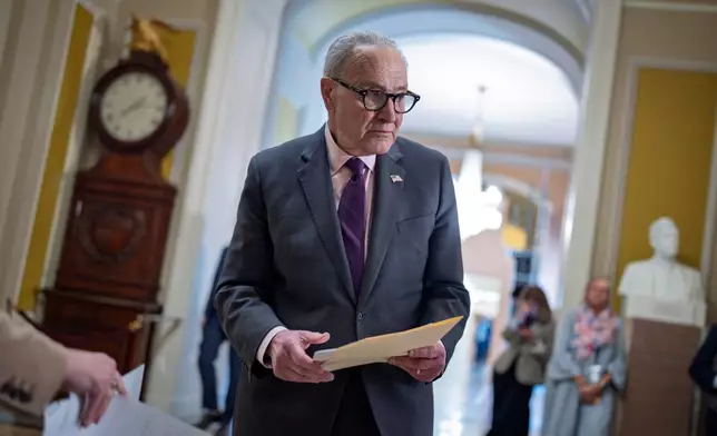 Senate Minority Leader Chuck Schumer, D-N.Y., goes over his notes before speaking to reporters following a closed-door party meeting, at the Capitol in Washington, Tuesday, April 21, 2026. (AP Photo/J. Scott Applewhite)