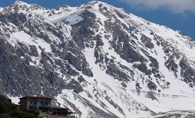 A chalet stands at the foothills of snow-covered Mount Parnassos in the popular winter resort town of Arachova, central Greece, on May 5, 2026. (AP Photo/Thanassis Stavrakis)