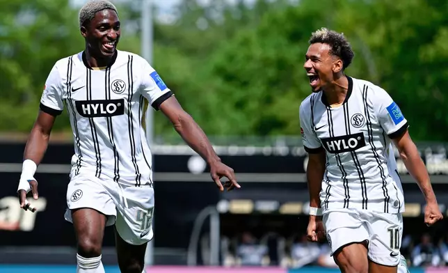 Elversberg's David Mokwa, left, celebrates scoring their second goal of the game with Bambase Conte during the Bundesliga 2 soccer match between SV Elversberg and SC Preußen Münster in Spiesen-Elversberg, Germany, Sunday May 17, 2026. (Uwe Anspach/dpa via AP)