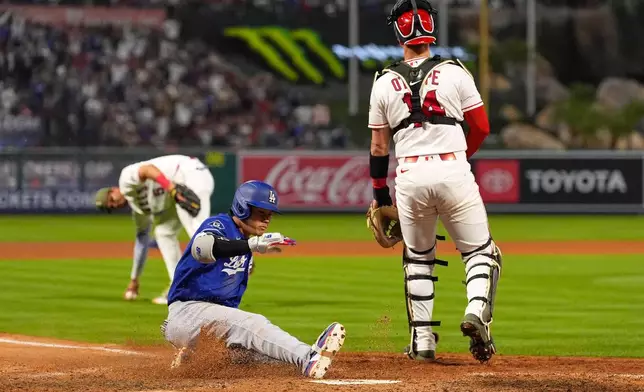Los Angeles Dodgers' Shohei Ohtani, center, scores on his two-run triple after a throwing error as Los Angeles Angels catcher Logan O'Hoppe, right, stands at the plate and third baseman Vaughn Grissom picks up the ball during the eighth inning of a baseball game Saturday, May 16, 2026, in Anaheim, Calif. (AP Photo/Mark J. Terrill) CORRECTION: After official review, changed from three-run inside-the-park home run to two-run triple after a throwing error