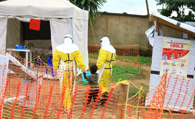 FILE - Health workers walk with a boy suspected of having the Ebola virus at an Ebola treatment center in Beni, eastern Congo, Sept 9, 2018. (AP Photo/Al-hadji Kudra Maliro, File)