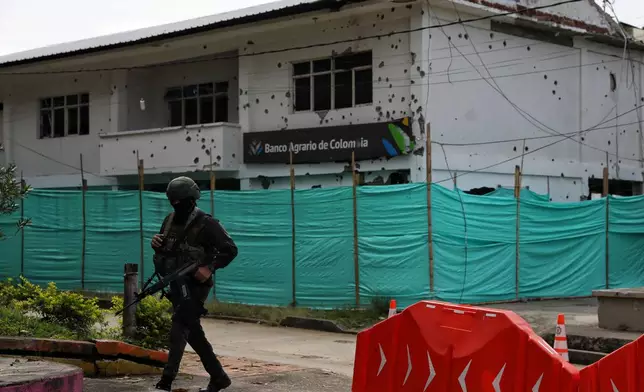 A police officer walks near a branch of the Banco Agrario damaged in an attack by dissidents of the former Revolutionary Armed Forces of Colombia, or FARC, in Buenos Aires, Cauca, ahead of Colombia's presidential election, Wednesday, May 20, 2026. (AP Photo/Santiago Saldarriaga)