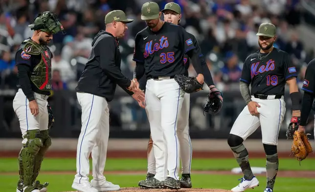 New York Mets starting pitcher Clay Holmes (35) heads to the dugout while being pulled by manager Carlos Mendoza during the fifth inning of a baseball game against the New York Yankees, Friday, May 15, 2026, in New York. (AP Photo/Yuki Iwamura)