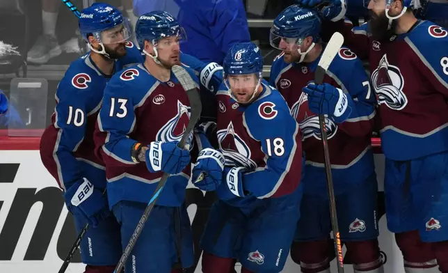Colorado Avalanche center Jack Drury, center, is congratulated by, from left, center Nicolas Roy, right wing Valeri Nichushkin, and defensemen Devon Toews and Brent Burns in the third period of Game 5 of an NHL Stanley Cup hockey second-round playoff series against the Minnesota Wild Wednesday, May 13, 2026, in Denver. (AP Photo/David Zalubowski)