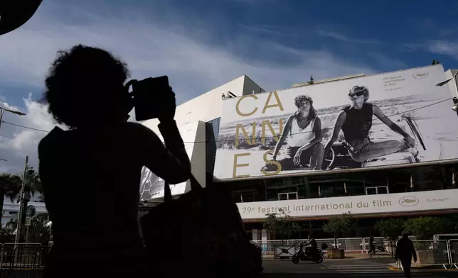 A person takes a photo outside the Palais des Festivals during preparations for the 79th international film festival, Cannes, southern France, Monday, May 11, 2026. (AP Photo/John Locher)