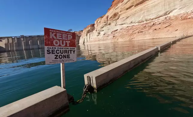 FILE - A sign reading "keep out" is displayed just upstream of Glen Canyon Dam at Lake Powell, June 8, 2022, in Page, Ariz. (AP Photo/Brittany Peterson, File)