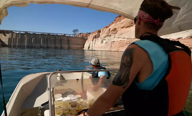 FILE - Utah State University master's student Barrett Friesen steers a boat near Glen Canyon dam on Lake Powell on June 7, 2022, in Page, Ariz. (AP Photo/Brittany Peterson, File)