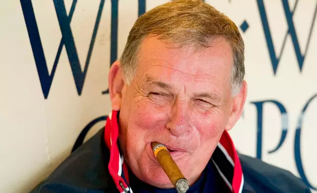 FILE - Atlanta Braves manager Bobby Cox smiles while smoking a cigar in the dugout with his coaching staff before the start of workouts Feb. 22, 2004, in Lake Buena Vista, Fla. (AP Photo/Scott Audette, File)