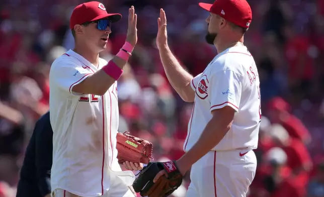 Cincinnati Reds' JJ Bleday, left, and pitcher Graham Ashcraft high five at the end of a baseball game against the Houston Astros, Sunday, May 10, 2026, in Cincinnati. (AP Photo/Kareem Elgazzar)
