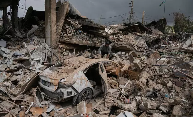 A man inspects his damaged car amid the rubble of shops destroyed in previous Israeli airstrikes in the Hosh neighborhood of Tyre, southern Lebanon, April 19, 2026. (AP Photo/Bilal Hussein)