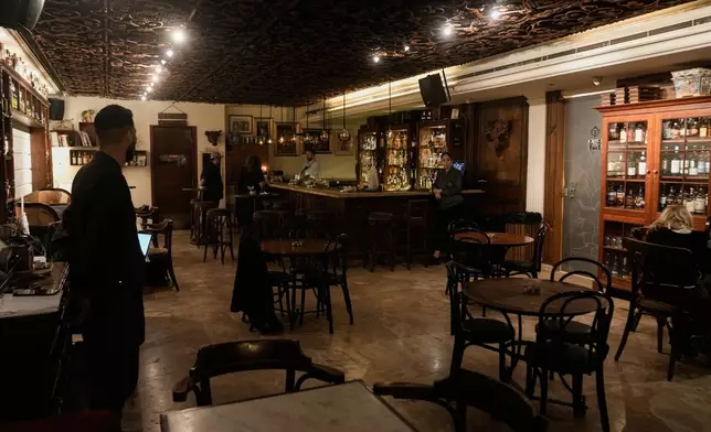 People spend time at an almost empty bar on Hamra Street in Beirut, Lebanon, May 5, 2026. (AP Photo/Bilal Hussein)