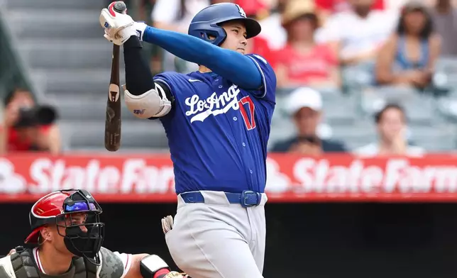Los Angeles Dodgers' Shohei Ohtani follows through on an RBI single during the fourth inning of a baseball game against the Los Angeles Angels, Sunday, May 17, 2026, in Anaheim, Calif. (AP Photo/Jessie Alcheh)