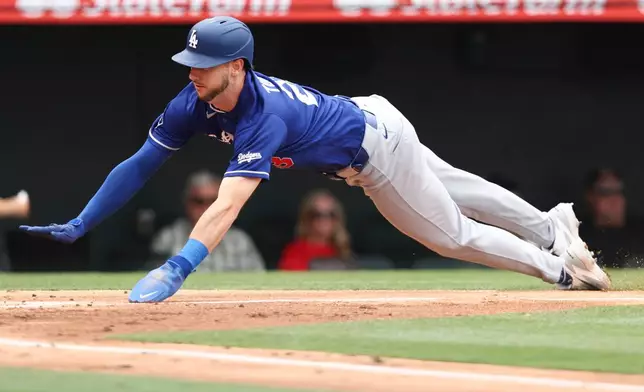 Los Angeles Dodgers' Kyle Tucker slides into home plate to score off of a sacrifice fly by Miguel Rojas during the second of a baseball game against the Los Angeles Angels, Sunday, May 17, 2026, in Anaheim, Calif. (AP Photo/Jessie Alcheh)