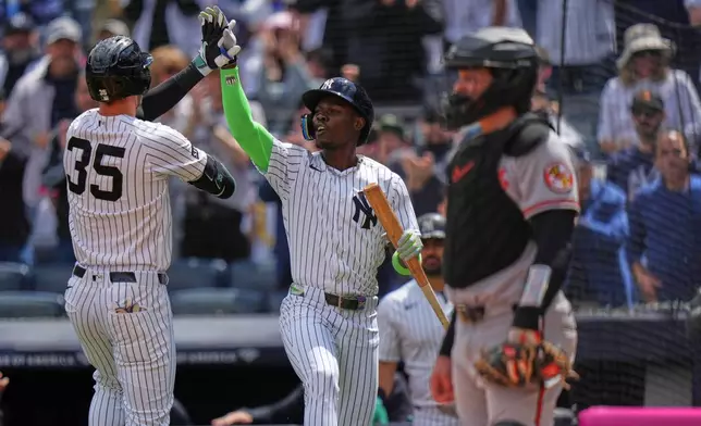 New York Yankees' Cody Bellinger, left, celebrates with teammate Jazz Chisholm Jr. as Baltimore Orioles catcher Adley Rutschman, right, looks away during the second inning of a baseball game Saturday, May 2, 2026, in New York. (AP Photo/Frank Franklin II)
