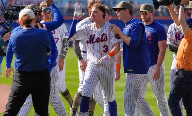New York Mets' Carson Benge, center, celebrates with teammates after he hit into the game-winning fielders choice during the tenth inning of a baseball game against the New York Yankees, Sunday, May 17, 2026, in New York. (AP Photo/Seth Wenig)