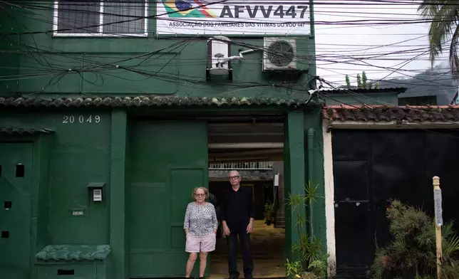 Nelson Faria Marinho and Maria Eva Marinho, who lost their son Nelson Marinho in the Air France flight 447 plane crash near the coast of Brazil on June 1, 2009, pose for a photo outside their home, where a sign with the flight number hangs in Rio de Janeiro, Thursday, May 21, 2026. (AP Photo/Bruna Prado)