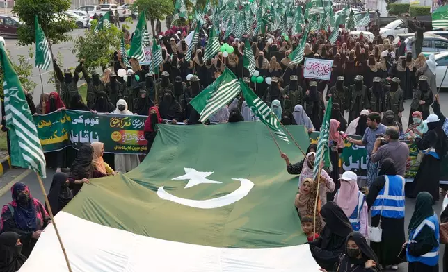 Supporters of the Muslim women league Pakistan, hold a giant Pakistani flag during a rally to mark the anniversary of last year's four-day conflict with neighboring India, Thursday, May 7, 2026, in Lahore, Pakistan. (AP Photo/K.M. Chaudary)