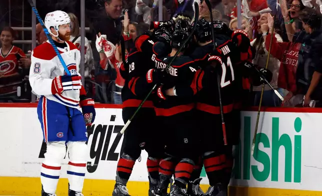 Carolina Hurricanes players celebrate after a goal by Eric Robinson as Montreal Canadiens' Mike Matheson (8) skates by during the first period in Game 5 of the Eastern Conference finals NHL hockey Stanley Cup playoff series in Raleigh, N.C., Friday, May 29, 2026. (AP Photo/Karl DeBlaker)