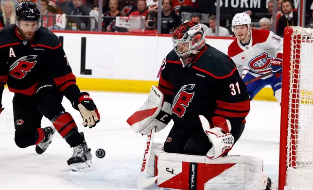 The puck bounces between Carolina Hurricanes goaltender Frederik Andersen (31) and Jaccob Slavin (74) with Montreal Canadiens' Cole Caufield (13) nearby during the first period in Game 5 of the Eastern Conference finals NHL hockey Stanley Cup playoff series in Raleigh, N.C., Friday, May 29, 2026. (AP Photo/Karl DeBlaker)