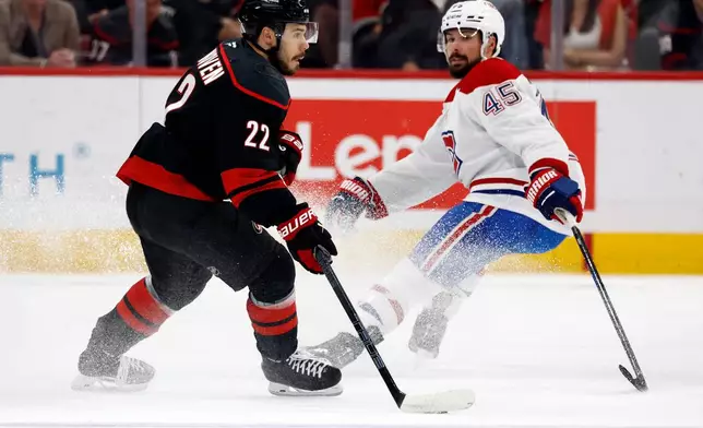 Carolina Hurricanes' Logan Stankoven (22) controls the puck with Montreal Canadiens' Alexandre Carrier (45) nearby during the first period in Game 5 of the Eastern Conference finals NHL hockey Stanley Cup playoff series in Raleigh, N.C., Friday, May 29, 2026. (AP Photo/Karl DeBlaker)