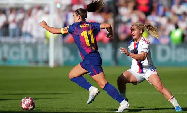 Barcelona's Alexia Putellas runs with the ball away from Lyonnes' Lindsey Heaps, right, during the Women's Champions League final soccer match between FC Barcelona and OL Lyonnes, in Oslo, Saturday, May 23, 2026. (AP Photo/Kirsty Wigglesworth)