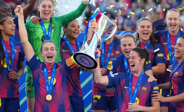 Barcelona's Alexia Putellas, left, and Marta Torrejon celebrate with the trophy after winning the Women's Champions League final soccer match between FC Barcelona and OL Lyonnes, in Oslo, Saturday, May 23, 2026. (AP Photo/Kirsty Wigglesworth)