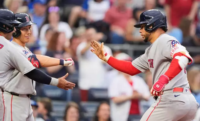 Boston Red Sox's Willson Contreras, right, celebrates with teammates after hitting a two-run home run during the sixth inning of a baseball game against the Kansas City Royals, Monday, May 18, 2026, in Kansas City, Mo. (AP Photo/Charlie Riedel)