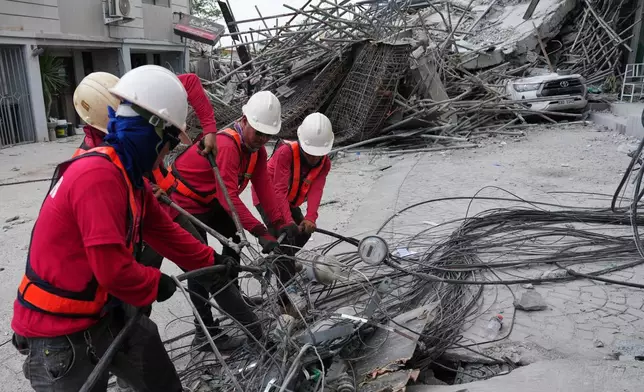Workers cut cables during a search operation at a collapsed building where multiple people are believed to be trapped in Angeles city in Pampanga province, north of Manila, Philippines, Monday, May 25, 2026. (AP Photo/Aaron Favila)
