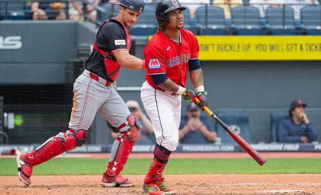 Cleveland Guardians' Jose Ramirez watches his RBI sacrifice fly as Washington Nationals' Drew Millas looks away during the fifth inning of a baseball game, Wednesday, May 27, 2026, in Cleveland. (AP Photo/Phil Long)