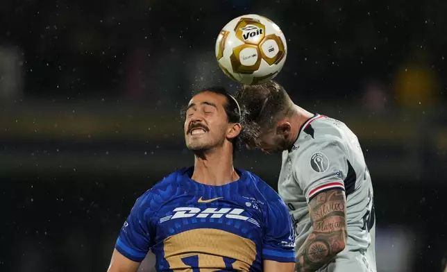 Pumas' Pablo Bennevendo, left, and Cruz Azul's Rodolfo Rotondi jump for a header during the Mexican soccer league second leg final match in Mexico City, Sunday, May 24, 2026. (AP Photo/Fernando Llano)