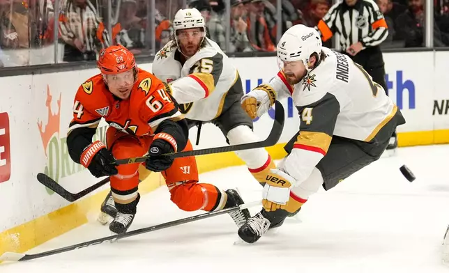Anaheim Ducks center Mikael Granlund, left passes the puck while under pressure from Vegas Golden Knights defenseman Rasmus Andersson during the first period in Game 3 of a second-round NHL hockey Stanley Cup playoff series Friday, May 8, 2026, in Anaheim, Calif. (AP Photo/Mark J. Terrill)