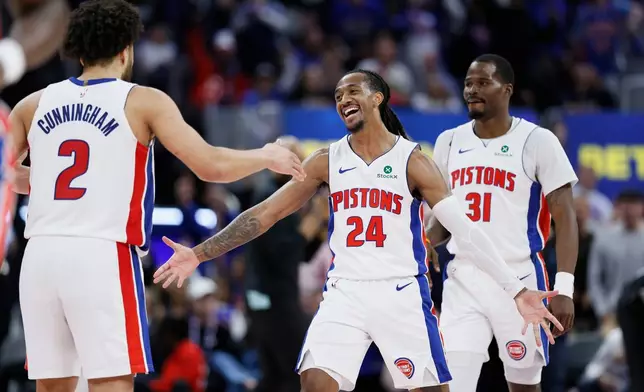 Detroit Pistons guard Daniss Jenkins (24) celebrates with guards Cade Cunningham (2) and Javonte Green (31) after sinking a three-point basket against the Orlando Magic during the fourth quarter in Game 7 of a first-round NBA basketball playoffs series Sunday, May 3, 2026, in Detroit. (AP Photo/Duane Burleson)