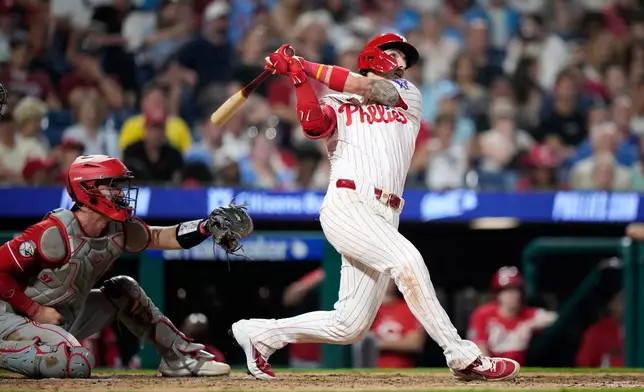 Philadelphia Phillies' Bryson Stott follows through after hitting a two-run home run against Cincinnati Reds pitcher Graham Ashcraft during the eighth inning of a baseball game Monday, May 18, 2026, in Philadelphia. (AP Photo/Matt Slocum)