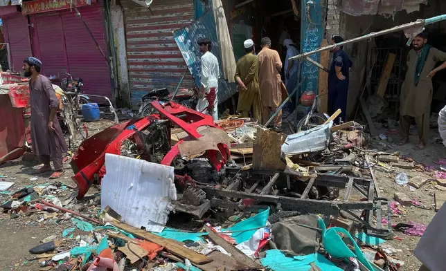 Local residents examine damage at the site of a bomb explosion at a market in Sarai Norag in Lakki Marwat, a district in Pakistan's Khyber Pakhtunkhwa province, Tuesday, May 12, 2026. (AP Photo/Farhat Ullah)