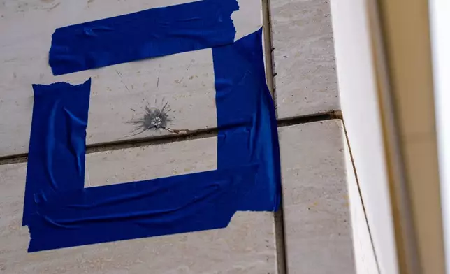 Blue tape is pictured around a possible bullet strike near the shooting scene near the scene of a shooting close to the White House, Sunday, May 24, 2026, in Washington. (AP Photo/Alex Brandon)