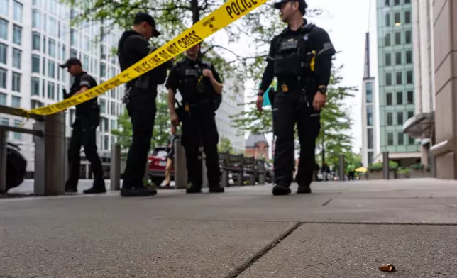 U.S. Secret Service Police officers place crime scene tape after a copper jacket of a bullet was found near the scene of a shooting close to the White House, Sunday, May 24, 2026, in Washington. (AP Photo/Alex Brandon)