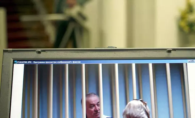 FILE - Sergei Skripal, left, is seen on a screen speaking to his lawyer from behind bars in Moscow on Aug. 9, 2006. (AP Photo/Misha Japaridze, File)