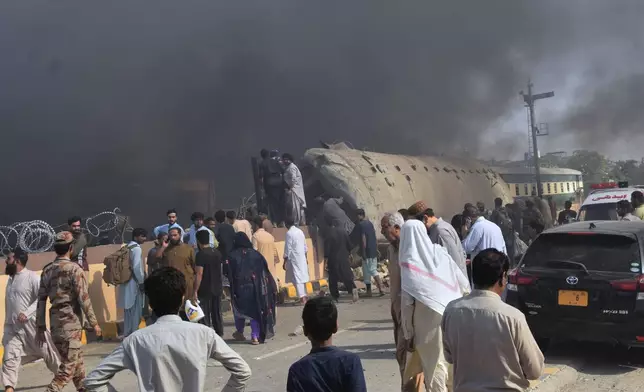 Paramilitary soldiers and volunteers recover victims from an overturned train coach on a railway track at the site of bomb explosion, in Quetta, Pakistan, Sunday, May 24, 2026. (AP Photo/Arshad Butt)