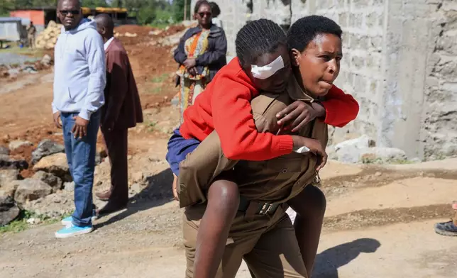 An injured student is evacuated following an early morning fire outbreak at Utumishi Girls School in the Gilgil area, central Kenya, Thursday, May 28, 2026. (AP Photo/Andrew Kasuku)