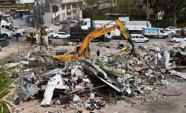 Residents inspect the site of an Israeli army demolition campaign that targeted several Palestinian commercial structures overnight, days after the issue of demolition and evacuation orders to owners, in the West Bank town of Al-Eizariya Tuesday, May 12, 2026. (AP Photo/Mahmoud Illean)