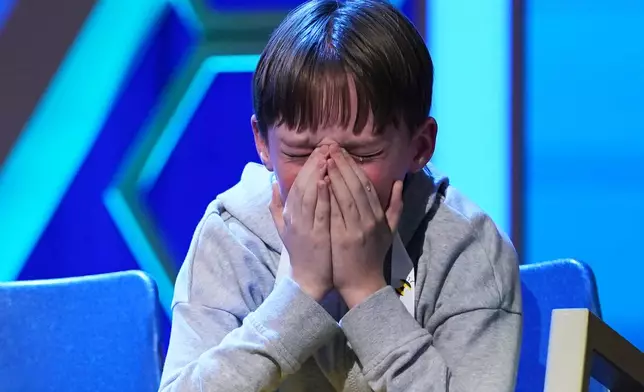 Logan Bailey, 12, of Houston, Texas, reacts during the final round of the 2026 Scripps National Spelling Bee in Washington, Thursday, May 28, 2026. (AP Photo/Allison Robbert)